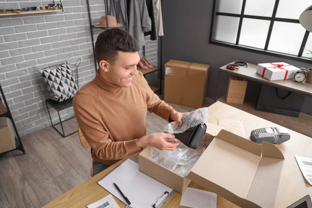 Maleonlinestoresellerpackingbagattableinwarehouse